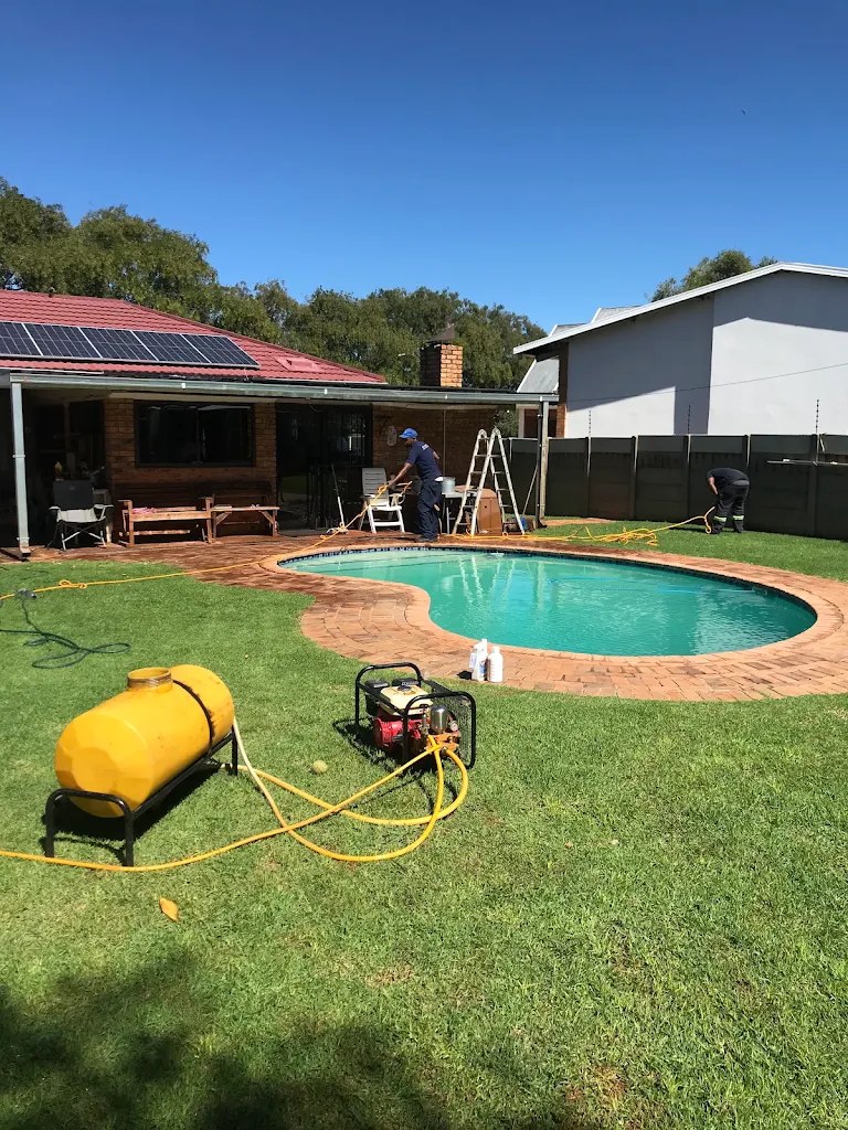 Zenzele Pest Control technician treating a backyard pool area